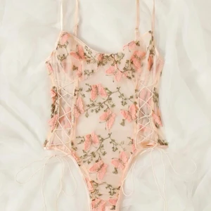 bodysuit med blommor - En bodysuit i mesch med blommor