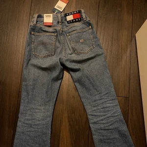 Helt nya Tommy Hilfiger jeans, strl w24 - Sprillans nya och oanvända jeans från Tommy Hilfiger jeans! Tags sitter kvar så de är helt nya!  Storlek W24 L32  Nya kostar de 1200kr  Hör av dig om du har fler frågor, annars fynda!!