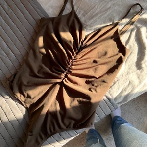 Brun body  - Brun body från Bikbok i storlek S, den har skyaterbara band så den passar alla storlekar skulle jag säga. Riktigt fin till fest eller middag. Kan macha den med precis allt. Aldrig andvänt endast testat. För fler bilder elr frågor kontakta mig. Valfri frakt såklart!