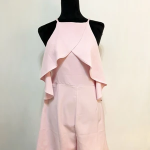 Rosa kort byxdress - Amisu Storlek 42 - Fin och gullig kort byxdress med volangdetaljer som passar både till vardags och festligheter. Den perfekta byxdressen till sommartiderna. Den är helt oanvänd och är i nyskick. Säljer för 149