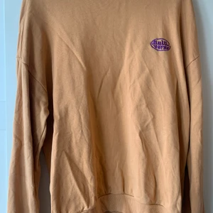 Jankyard sweatshirt - Orange sweatshirt men lila tryck ifrån jankyard, använd några få tal gånger men nästa som ny.