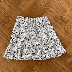 Kjol - Svartvit kjol från shein i storlek xs! Vit med svarta prickar. Resår i midjan och volang nertill. Aldrig använd så i väldigt fint skick! 