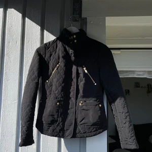 Svart jacka med gulddetalj nyskick - Svart ridimiterad jacka från Ginatricot med gulddetaljer. Figursydd. Storlek XS passar S. Oanvänd, bra skick. 