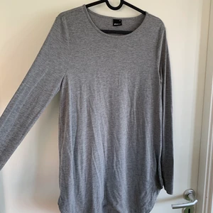 Basic grå topp i längre modell - Grå långärmad topp från Gina Tricot i storlek M. Längre i modellen, och med tunt tyg. Sparsamt använd!