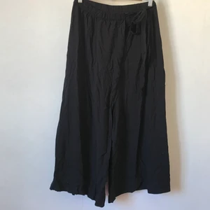 Svarta byxor, Weekday, 36 - Underbart flowy byxor från Weekday! Vida ben och knyte i midjan som går litet ”omlott”. Storlek 36 men 34 säkert mot 38 går också bra. 100% viscose. Ostrukna på bild! Förlåt. Kan mötas i Stockholm eller skicka mot fraktkostnad! ✨🌸✨