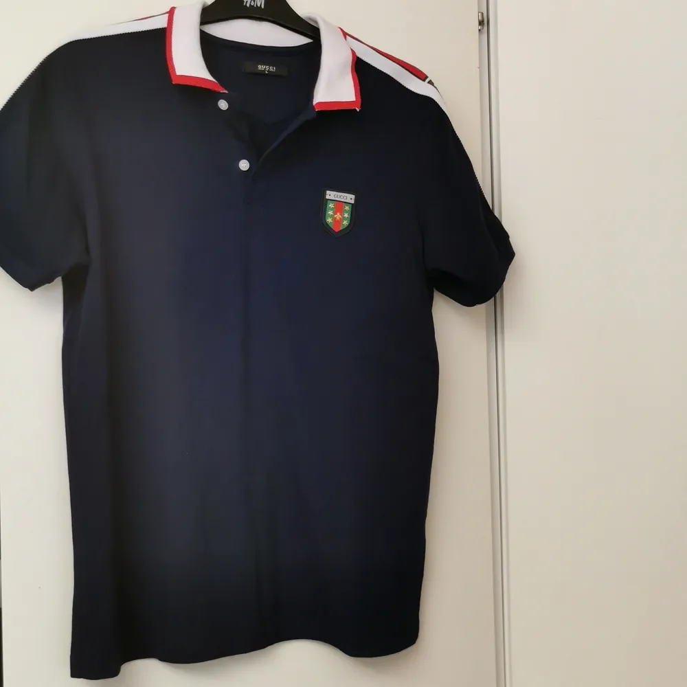 En mörkblå Gucci T-shirt. Gucci T-shirt gjord i Italien. T-shirten har används ett par gånger men inte mycket. Den har storleken L och märket GUCCI på ärmen och på bröstet. . T-shirts.