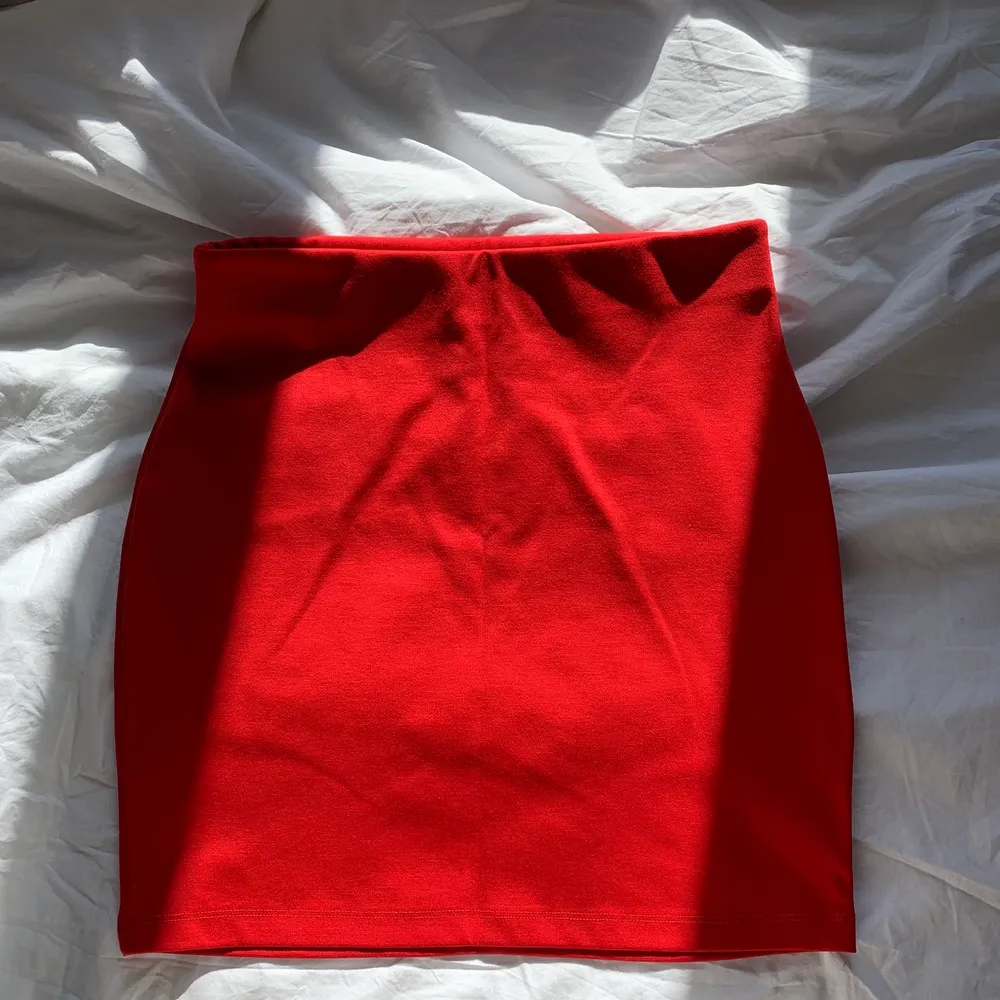 Röd kort kjol i stretch, Storlek S. Kjolar.