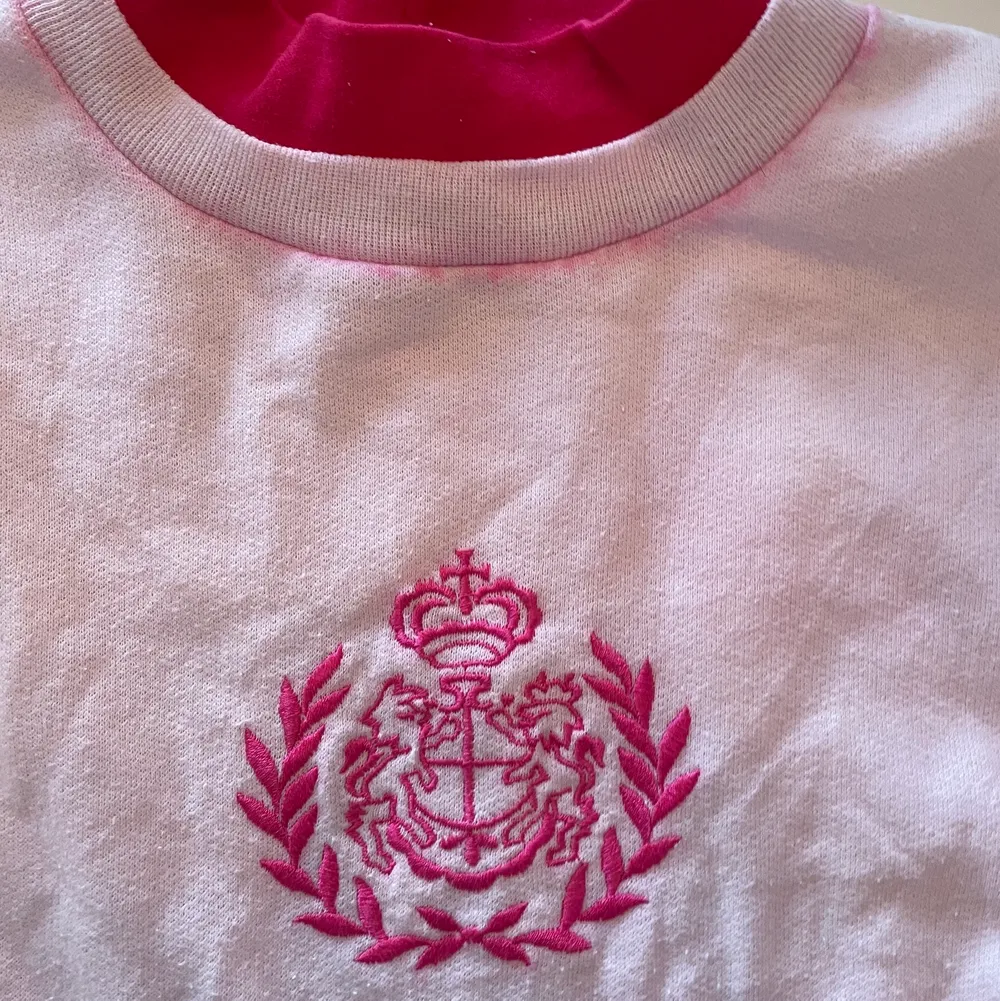 Rosa sweatshirt med dubbelkrage och broderat märke. Står storlek M men passsar som en kvinnlig S.. Tröjor & Koftor.