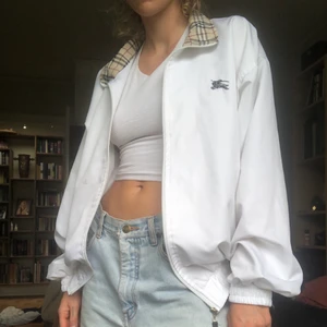 Burberry jacka!  - en asfet jacka med stort burberry-tryck på ryggen och rutiga detaljer på krage o fickor.  Står storlek L men skulle säga att de passar alla fr S-L. !OBS! en grå fläck fram på jackan på höger sida ca 2cmx3cm