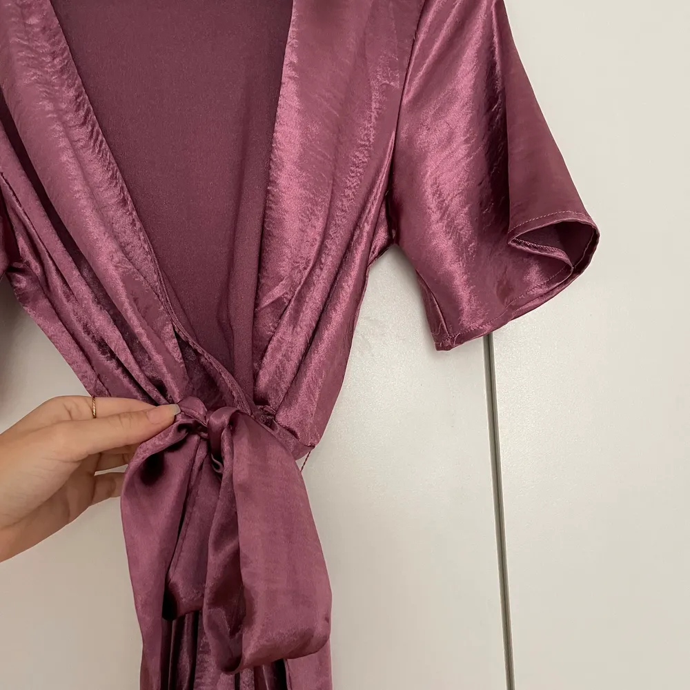 Omlott-klänning i skimrande mörk rosa från NAKD, aldrig använd - storlek S. Klänningar.