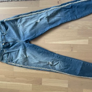 Byxor med pärldetaljer - Byxor med pärlor längst benen. Använda ett fåtal gånger. Storlek 30/32