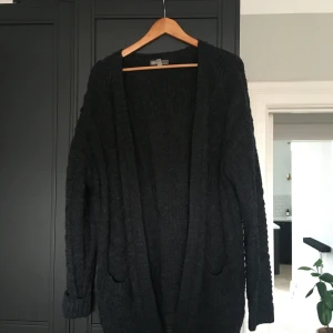 Mörkgrå kabelsticksd kofta strl M - Ny och knappt använd snygg kofta i strl M, 80 % akryl/20 % ull.