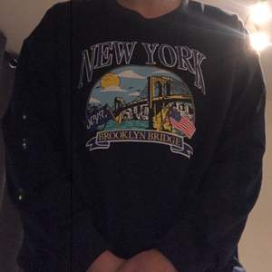 Blå sweatshirt där det står new york på