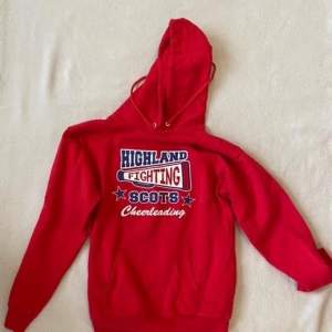 Röd Highland Scots Cheerleading-hoodie med tryck på ryggen. Se bild