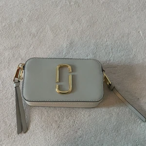 Äkta Marc Jacobs axelremsväska  - Säljer min äkta marc jacobs väska då den inte kommer till användning. Använt den ett fåtal gånger så därav inga slitningar eller märken. Finns ej kvar att köpa på nätet, köpt för 3400kr. Buda från 1500. 💕