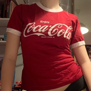 Coca cola tröja! - Jättesöt coca cola tshirt. Den går in i midjan och är inte baggy som t-shirts brukar vara! Köpt för massa år sedan och har legat längst bak i garderoben. Passar S/M skulle jag gissa