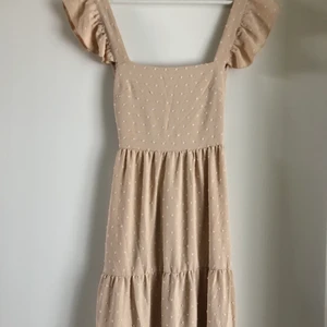 Klänning - Superfin beige långklänning med vita prickar!!!🤎🤍 Storlek XS men skulle säga att den passar även storlek S & M då den har resår i bak och man knyter själv i ryggen. Aldrig använd så nyskick!!  (sista två bilderna är lånade och visar passformen i samma klänning i vit) 