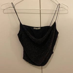 Snygg topp i guld glittrigt material - Aldrig använt