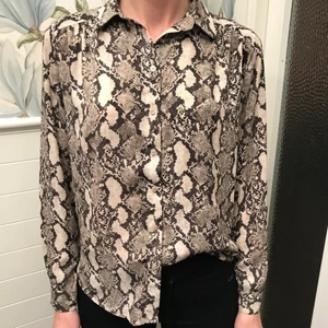 Skjorta i ormmönster - Superfin blus/skjorta i ormmönster!! Jag skulle säga att denna är i nyskick💓 på bild 2&3 syns veckade detaljer. Skriv för frågor! 🤝🤝