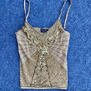 Glittrigt linne - Säljer ett linne med paljetter. Y2k topp! Fint skick, strl 36/38 skulle jag uppskatta den som. Köpare står för frakt🧡💛