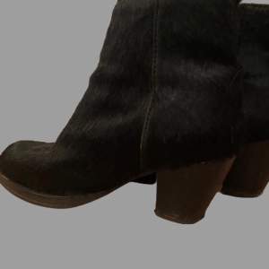 svarta cowboy inspirerade boots med klack. Svarta och lite fluffiga