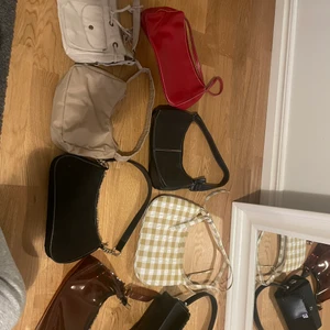 handväska - Säljer flera fina handväskor pga att jag inte får använding av dom. Den bruna, vit/bruna, ljusrosa och svarta med gulddetaljer är i nyskick medan resten är köpta second-hand men alla är i fint skick! 100-150kr styck beroende på väska. Frakt tillkommer💕