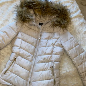 Beige jacka - Beige jacka med gulddetaljer från only i strl xs🤎 perfekt nu mot höst/vinter. Fuskpälsen på huvan går att ta av. Aningen för kort på mig så kommer därför tyvärr inte till användning, fint skick!