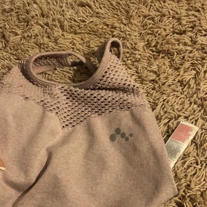 Sport topp  - En fin träningstopp i smuts rosa/lila färg. Sitter bra och håller allt på plats. Korsning vid ryggen.