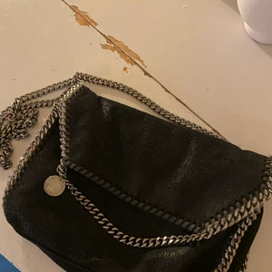 Stella McCartney väska  - Tänkte nu kolla intresset för min lilla Stella McCartney väska då den inte längre kommer till någon användning för mig. Väskan är äkta köpt i butik för några år sedan. Den är i andvändt skick men absolut fortfarande väldigt fin men inte i nyskick. Kan mötas upp i Göteborg eller frakta, står för frakten. Modellen har jag för mig heter Falabella mini crossbody. Bud ifrån 450.