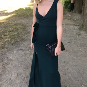 Långklänning - Jätte fin klänning som passar perfekt till balen. Smickrande passform som är tajtare upptill. En mörkgrön färg med band i sidan så man kan reglera midjan. Slits samt lite längre baktill. Jag är 163cm och den är bra i längden både utan och med klack. 