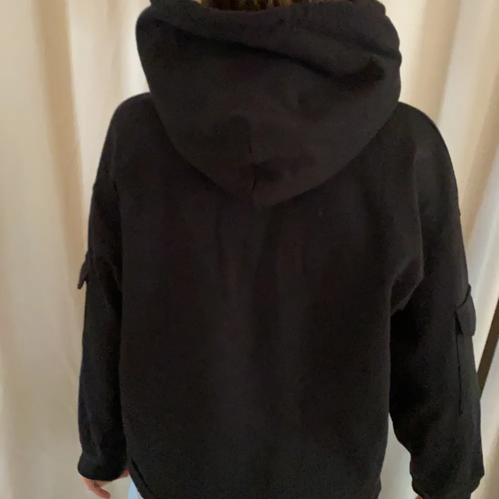 Snygg svart hoodie med fickor på ärmen . Köparen står för frakt :). Hoodies.