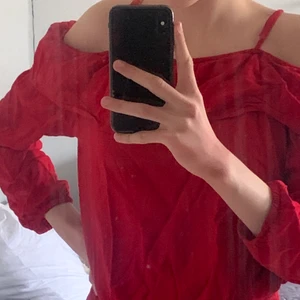 Röd tröja med volang storlek XS/S - Röd, tunn tröja med volang från hm. Tröjan är i mycket gott skick och använd en gång. Den är ribbad nertill och banden vid axlarna går att reglera. 