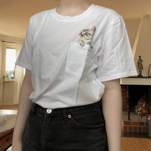 En söt t-shirt från H&M med en katt i bröstfickan! Frakt 45 kr 🌿 Finns i Västerås och tillfälligt Malung. 