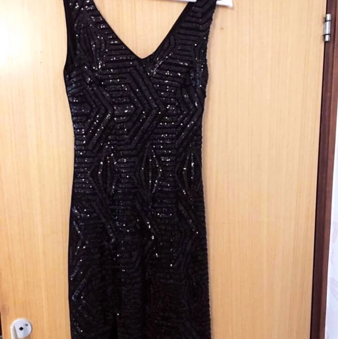 En lång svart glitter klänning köpt från Nelly.