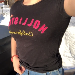 Hollister t-shirt svart - En svart rätt tajt t-shirt från Hollister. Rosa märke på bröstkorgen. Väl använd men i fint skick.