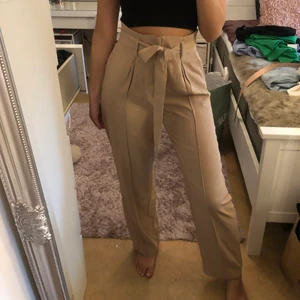 Beige bruna kostymbyxor  - Ett par brun/beiga kostymbyxor köpt från bikbok, i storlek 36. Använd endast 1-2 ggr. Jag är 165 cm. 