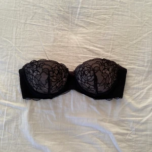 Svart bh utan band - En svart bh med spets och en beige under färg. Finns inga band till för att dom har jag tagit bort. Är i bra skick förutom innre sidan på bh-n där jag tagit bort banden. Men stör inte när den sitter på.
