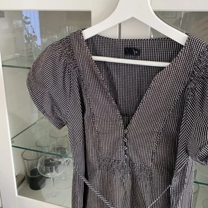 Rutig klänning  - Säljer denna gulliga klänning från Lindex i jättefint skick! Knytning i midjan😊 Köpt på second hand! Står ingen storlek i men passar storlek 34/36/38. Skriv privat vid intresse💗 Frakt tillkommer på 57kr (spårbar)📦