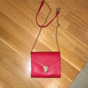 En fin röd väska som man lätt kan få i mobil,plånbok och andra små grejer! Själv tycker jag den är jätte fin!💅🏼 - Den är mörk röd färg men åndå inte så mörk,den är ca13cm bredd jag är inte säker 🤔 man kan ha den på natt och på dag!🦋bredd är den 12CM och höjd 15CM