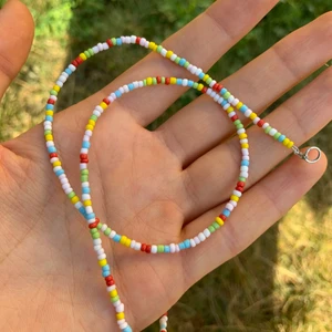 Pärlhalsband  - Hemgjort halsband på metalltråd med hasp i nacken. Halsbandet är 40 cm. 