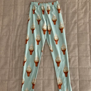 Coola yoga tights med glasstryck - Yoga tights med glass tryck! Perfekt för att pigga upp vardagen. Tyget är mjukt och stretchigt. Dem är klippta nedtill vid benen och går att t.ex. klippa till kortare cykeltights om man vill. Sparsamt använda. Endast swish, köparen står för frakten.