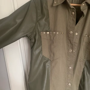 Grön jeans jacka - Säljer den här as coola jackan från zara, aldirg andvänd. Den är blandning mellan skinn och ”jeans” med super fina guld detaljer som gör den unikare. Insidan av ärmarna är mjuka då det är något slags ludd, vilket värmer och är mysigt! Är i storlek XS men passar mig som är S/M!! Hör av dig vid intresse🙌🏼(färgen framgår bäst på bild 2)