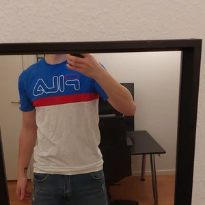 FILA - blå, röd och vit T-shirt  - Tröjan har en snygg färgklick som passar perfekt för en med stil. Bra skick. 
