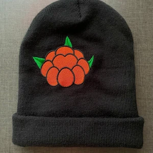 Norrlandsmössa i bra skick! - Knappt använd så är i samma skick som när den köptes. Gjort i mjukt garn och den är resorstickad. Påsytt stort märke med ett hjortron :) nypris ca 250kr