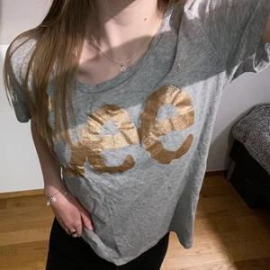 Lee thisha - Grå T-shirt med guldigt lee märke. Storlek m, knappt använd