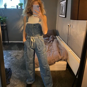 Hängslebyxor jeans  - Ett par hängselbyxor i jeans som jag köpt på beyond retro. De är i storlek S, men skulle även passa xs och M beroende på hur man vill att de ska sitta. De är i mycket bra skick, utan fläckar mm. 