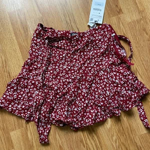 Kjol från zara  - Röd kort blommig kjol från zara. Oanvänd 