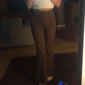 Bruna Utsvängda Kostymbyxor - Bruna, utsvängda kostymbyxor i skönt, stretchigt material från Monki. Sällan använda, därför säljer jag dom, jag är 170 cm lång för perspektiv:)