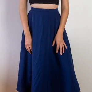 Blå lång kjol Uniqlo strl 34 / xs - Mörkblå kjol från Uniqlo med fint och tungt fall, sitter tajt i midjan. Väldigt fint skick. Strl 34 då den är väldigt tajt i midjan. 