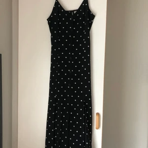 Prickig långklänning - Prickig långklänning med knappar och två slitsar från H&M.